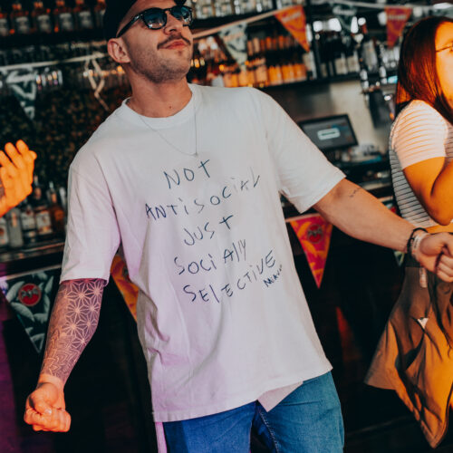 A man in a white T-shirt dancing at a bar