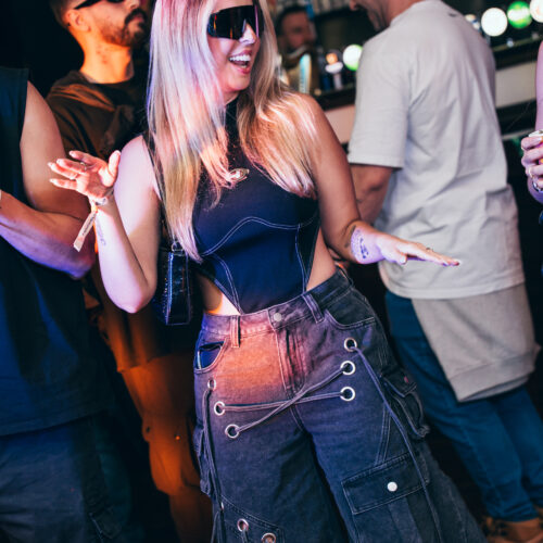 A woman in sunglasses dancing in the crowd